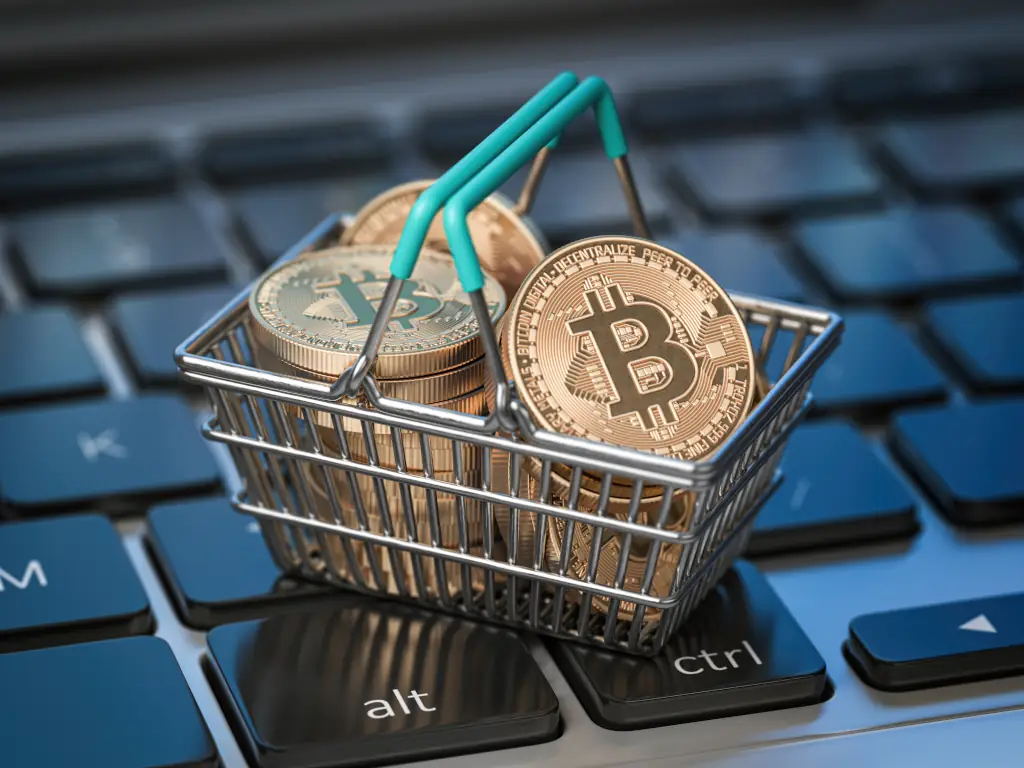 Bitcoin-Münzen im Einkaufswagen auf Laptop-Tastatur. Bitcoin Wallet und Zahlung